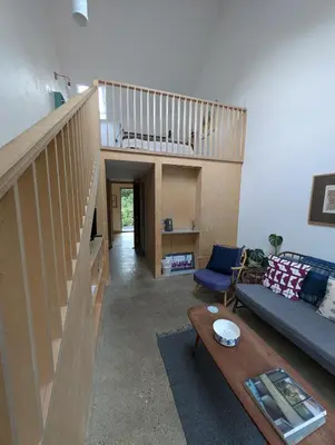 a living room with a staircase and a couch at Five Acre Barn in Aldringham