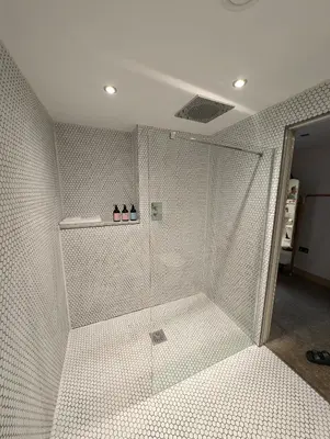 a shower with a glass door in a bathroom at Five Acre Barn in Aldringham