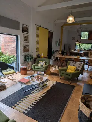 a living room with green chairs and a table at Five Acre Barn in Aldringham