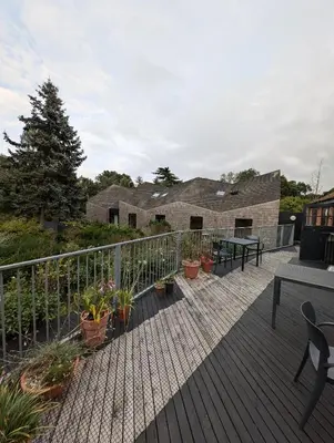 a deck with potted plants and a table and benches at Five Acre Barn in Aldringham