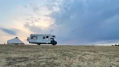 a camper van parked in a field with a tent at Surfer Mammut in Ipswich