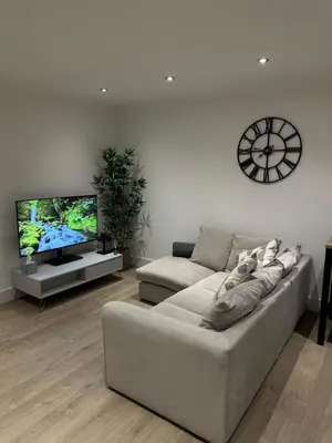 a living room with a couch and a tv at The Snug - Town Centre Apartment in Bishops Stortford