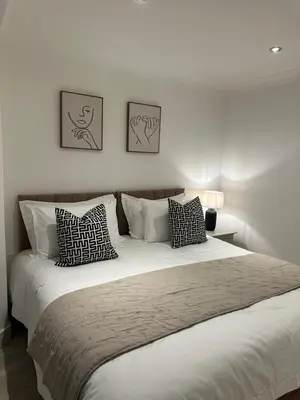 a bedroom with a large white bed with pillows at The Snug - Town Centre Apartment in Bishops Stortford