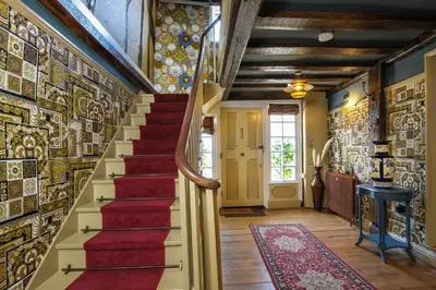 a staircase in a house with a red carpet at The Famous Harry Potter House in Saffron Walden