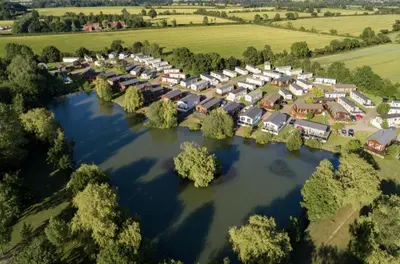 an aerial view of a resort on a river at Platinum lakeside Lodge on resort with fishing in Kelsale