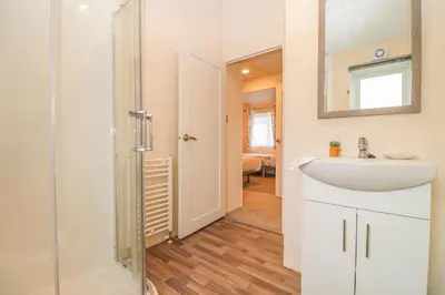 a bathroom with a sink and a mirror at Platinum lakeside Lodge on resort with fishing in Kelsale