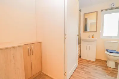 a bathroom with a toilet and a sink at Platinum lakeside Lodge on resort with fishing in Kelsale