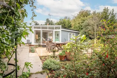 a tiny house in the garden with a patio at The Whins, Aldringham in Aldringham