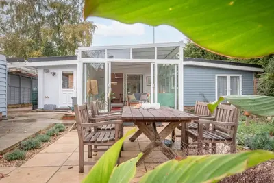 a patio with a wooden table and chairs at The Whins, Aldringham in Aldringham