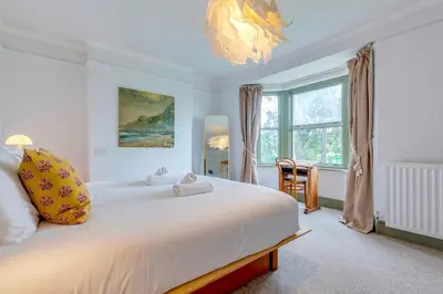 a bedroom with a large white bed and a window at Pass the Keys Charming Victorian Terrace in centre of Cambridge in Cambridge