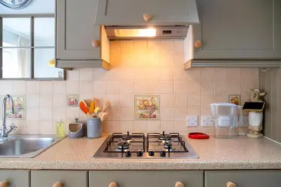 a kitchen counter with a stove and a sink at Pass the Keys Charming Victorian Terrace in centre of Cambridge in Cambridge