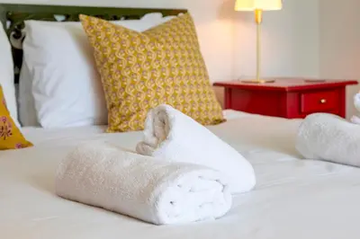 a pile of towels sitting on a bed at Pass the Keys Charming Victorian Terrace in centre of Cambridge in Cambridge