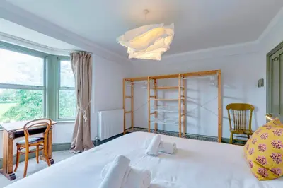 a bedroom with a large white bed and a window at Pass the Keys Charming Victorian Terrace in centre of Cambridge in Cambridge