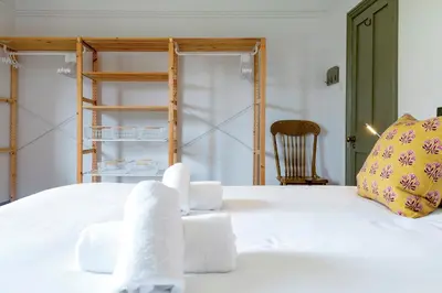 a bedroom with a white bed with towels on it at Pass the Keys Charming Victorian Terrace in centre of Cambridge in Cambridge
