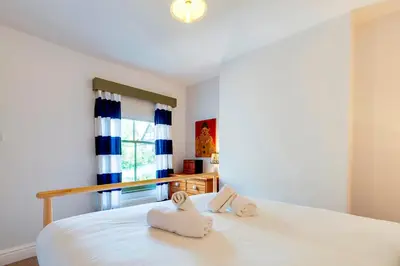 a bedroom with a white bed with towels on it at Pass the Keys Charming Victorian Terrace in centre of Cambridge in Cambridge