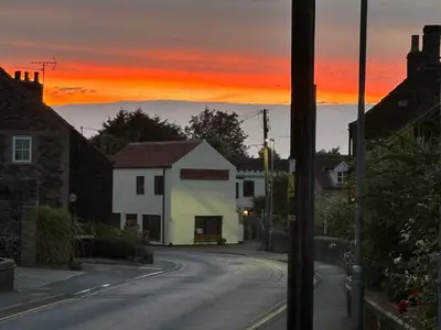 a house on a street with a sunset in the background at St Edmunds Brewery in Downham Market