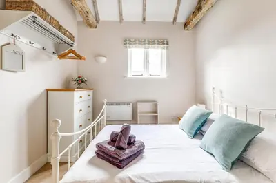 a bedroom with a white bed and a window at Harestreet Farm Barns, The Dairy, Parlour and Creamery in Cottered