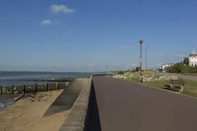 a road next to a beach with a lighthouse at Southend Guest House - Close to Beach, Train Station & Southend Airport in Southend-on-Sea
