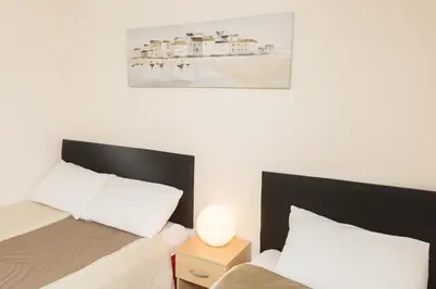 a bedroom with two beds and a painting on the wall at Southend Guest House - Close to Beach, Train Station & Southend Airport in Southend-on-Sea