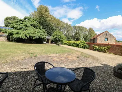 a table and chairs sitting in a yard at Pear Tree Cottage in Swaffham