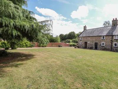 an old stone house with a large yard at Pear Tree Cottage in Swaffham