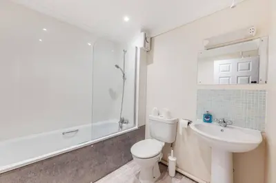 a white bathroom with a toilet and a sink at Harland Haven Spacious 4br House In Ipswich in Ipswich
