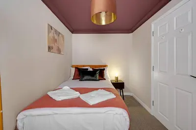 a bedroom with a bed with two towels on it at Harland Haven Spacious 4br House In Ipswich in Ipswich