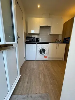 a small kitchen with a washing machine in it at 63 studio room for single or double occupancy in Brentwood