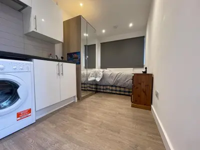a kitchen with a washer and dryer in a room at 63 studio room for single or double occupancy in Brentwood