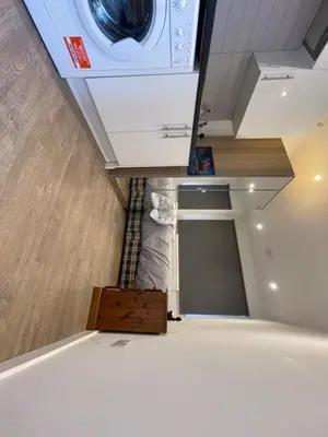 a kitchen with a washer and dryer on the ceiling at 63 studio room for single or double occupancy in Brentwood