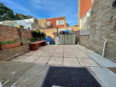 a driveway with a brick wall and a garage at 63 studio room for single or double occupancy in Brentwood