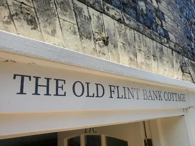 an old bird sitting on top of the old firm bank building at The Old Flint Bank Cottage in Harleston