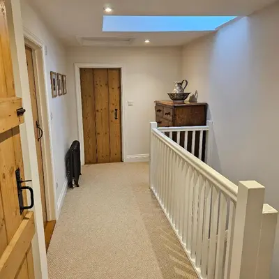 a hallway with a stairway with a skylight at The Old Flint Bank Cottage in Harleston