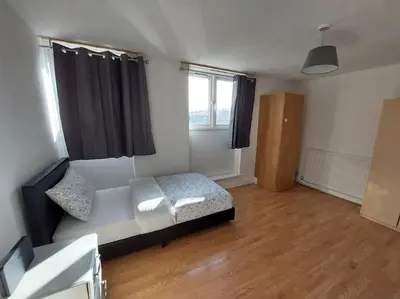a small bedroom with a bed and a window at 5 Bedroom House in Romford in Harold Wood
