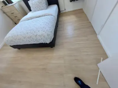 a bedroom with a bed and a wooden floor at 5 Bedroom House in Romford in Harold Wood