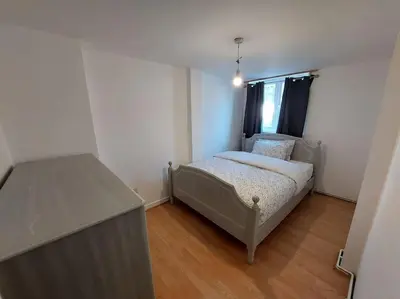 a small bedroom with a bed and a window at 5 Bedroom House in Romford in Harold Wood