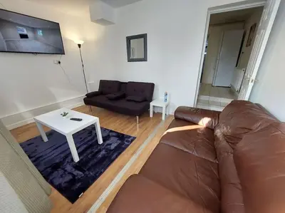 a living room with a couch and a table at 5 Bedroom House in Romford in Harold Wood