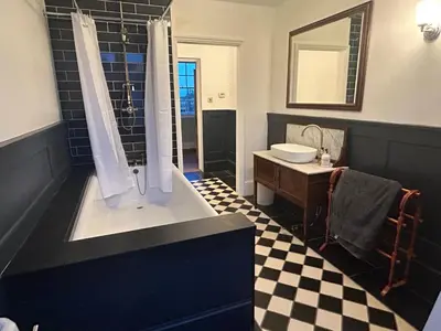 a black and white bathroom with a sink and a shower at Cockayne Hatley Hall in Cockayne Hatley