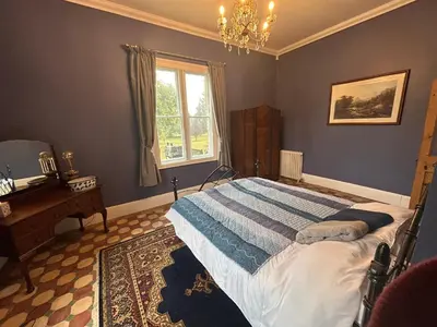 a bedroom with a bed and a desk and a window at Cockayne Hatley Hall in Cockayne Hatley