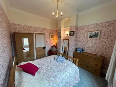 a bedroom with a bed and a dresser and a mirror at Cockayne Hatley Hall in Cockayne Hatley