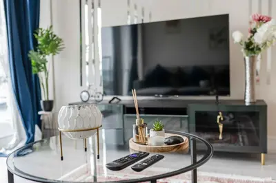 a glass coffee table in a living room with two remote controls at Ipswich Marina1 2 bed2bath apt in Ipswich
