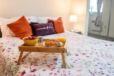 a tray of food on a bed with a tray of fruit at Ipswich Marina1 2 bed2bath apt in Ipswich