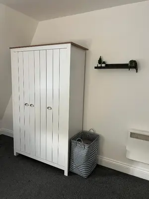 a white cabinet in a corner of a room at The Nook - Town Centre Apartment in Hoddesdon