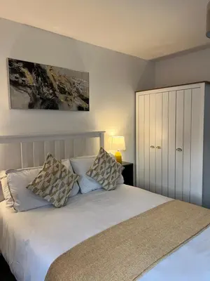 a bedroom with a white bed with two pillows at The Nook - Town Centre Apartment in Hoddesdon