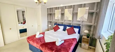 a bedroom with a bed with two swans on it at Chelmsford Comfort Retreat Spacious 4 Bedroom Sleeps 7 Free Parking in Widford