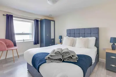 a bedroom with a bed with towels on it at Elm Cottage Ipswich in Ipswich