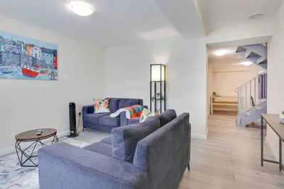 a living room with two blue couches and a table at Elm Cottage Ipswich in Ipswich