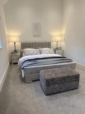 a bedroom with a large bed and two night stands at One Granary Barns near Stansted Airport in Elsenham