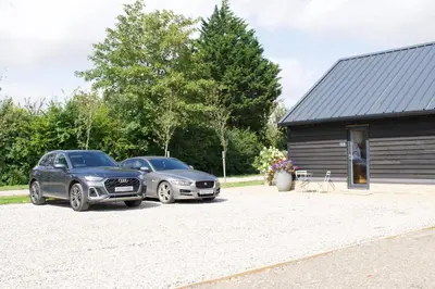 two cars parked in front of a building at One Granary Barns near Stansted Airport in Elsenham