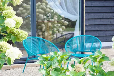two blue chairs sitting in front of a window at One Granary Barns near Stansted Airport in Elsenham